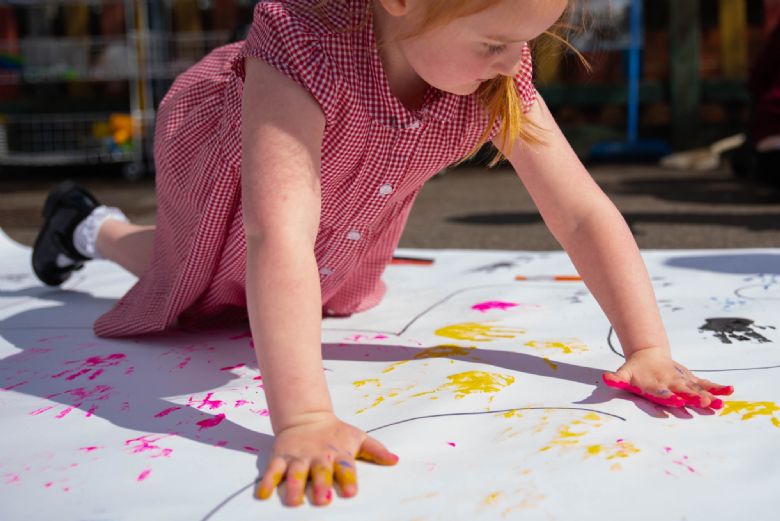 Child making coloured handprints